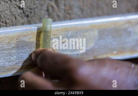 Ein Arbeiter, mason, überwacht den Wasserstand, um die Höhe und den Boden vor dem Zementieren zu nivellieren. Stockfoto