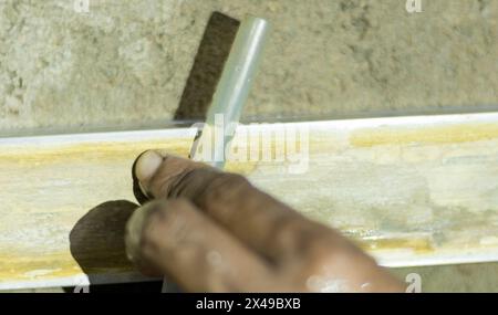 Ein Arbeiter, mason, überwacht den Wasserstand, um die Höhe und den Boden vor dem Zementieren zu nivellieren. Stockfoto