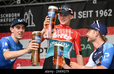 1. Mai 2024, Hessen, Frankfurt/Main: Radfahren: UCI WorldTour - Eschborn-Frankfurt, Männer. Der zweitplatzierte Alex Aranburu (l-r) aus Spanien vom Team Movistar, der belgische Sieger Maxim van Gils vom Team Lotto Dstny und der drittplatzierte Riley Sheehan aus den USA vom Team Israel – Premier Tech stoßen sich bei der Podiumseremonie an. Foto: Arne Dedert/dpa Stockfoto