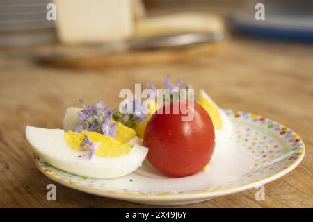 Zusammensetzung gekochter Eier Tomaten und Blumen Stockfoto