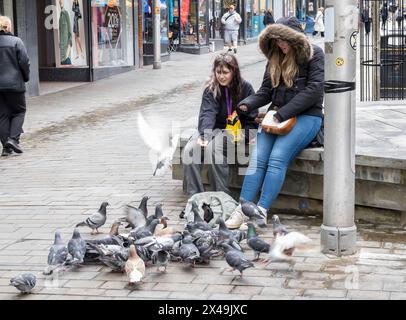 Fütterung der Tauben, High Street, Lincoln City, Lincolnshire, England, UK Stockfoto