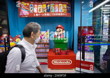 Osaka, Japan. April 2024. Man läuft mit Super Mario und Princess Peach an der Nintendo-Ausstellung in einem Einkaufszentrum in Osaka vorbei. (Foto: Stanislav Kogiku/SOPA Images/SIPA USA) Credit: SIPA USA/Alamy Live News Stockfoto