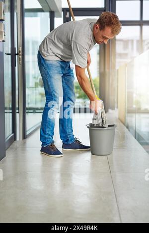 Hausmeister, Wischboden oder Reinigungsboden im Büro für die Hausreinigung, Gebäudewartung und Hygiene. Eimer, Hospitality Professional oder Hausmeister in Stockfoto