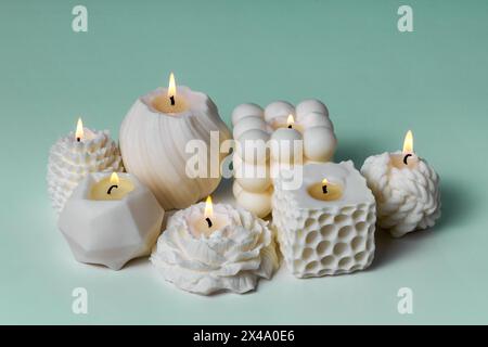 Handgemachte Kerzen aus Sojabohnenwachs auf blaublauem Hintergrund. Zarte Duftkerze aus natürlichen Materialien. Inneneinrichtung Stockfoto