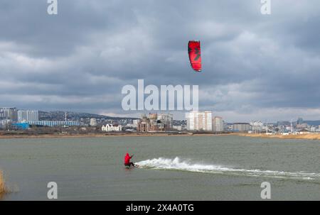 Ein Kitesurfer reitet und springt über die Wellen auf dem Schwarzen Meer. Stockfoto