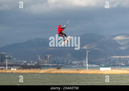 Ein Kitesurfer reitet und springt über die Wellen auf dem Schwarzen Meer. Stockfoto