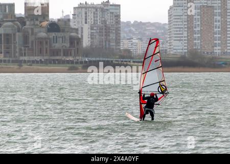 Ein Kitesurfer reitet und springt über die Wellen auf dem Schwarzen Meer. Stockfoto