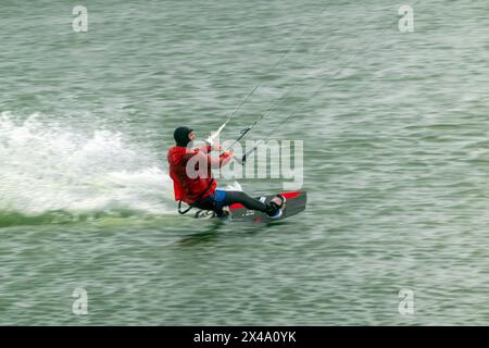 Ein Kitesurfer reitet und springt über die Wellen auf dem Schwarzen Meer. Stockfoto