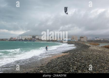 Ein Kitesurfer reitet und springt über die Wellen auf dem Schwarzen Meer. Stockfoto