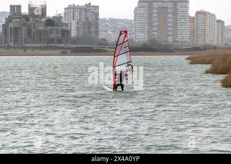 Ein Kitesurfer reitet und springt über die Wellen auf dem Schwarzen Meer. Stockfoto