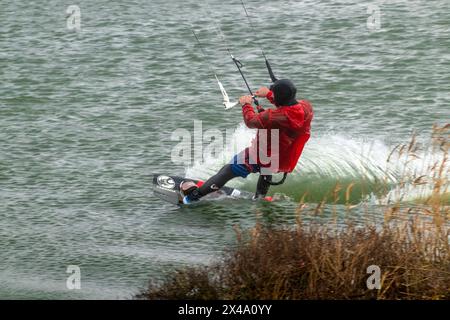 Ein Kitesurfer reitet und springt über die Wellen auf dem Schwarzen Meer. Stockfoto