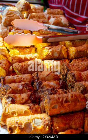 Hausgemachtes süßes Gebäck Cannolo siciiano gefüllt mit Mandel, Pistazien, Zitronen, Vanille, Schokoladencreme auf dem Lebensmittelmarkt Stockfoto