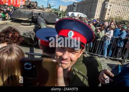 Moskau, Russland. Mai 2024. Besucher sehen und machen Fotos von einem in den USA hergestellten Abrams-Panzer M1A1, der im Vordergrund von russischen Truppen während der Sonderoperation in der Ukraine getroffen und gefangen genommen wurde, die in Moskau, Russland, ausgestellt ist. In der russischen Hauptstadt wurde eine Ausstellung mit militärischer Ausrüstung eröffnet, die während der Kämpfe in der Ukraine von Kiew eingenommen wurde. Quelle: Nikolay Vinokurov/Alamy Live News Stockfoto