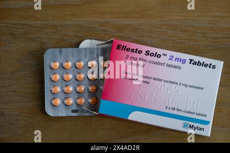 Blisterpackung mit Elleste Solo 2 mg Tabletten zusammen mit der Verpackung auf einer Holzoberfläche Stockfoto