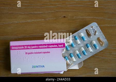Omeprazol 20 mg magensaftresistente Kapseln in Blisterpackung neben der Schachtel auf einer Holzoberfläche Stockfoto