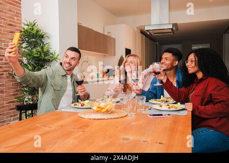 Eine Gruppe von Freunden nimmt ein Selfie-Porträt auf, während sie eine angenehme Mahlzeit genießen. Zwei Paare feiern Geburtstag und machen ein Erinnerungsfoto. Erwachsene Leute, die Spaß zusammen haben auf einem geselligen Treffen. Hochwertige Fotos Stockfoto
