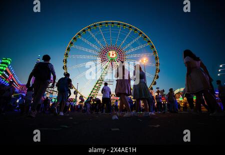 Stuttgart, Deutschland. Mai 2024. Zur blauen Stunde spazieren zahlreiche Menschen über den Cannstatter Wasen und besuchen das 84. Stuttgarter Frühlingsfest. Quelle: Christoph Schmidt/dpa/Alamy Live News Stockfoto