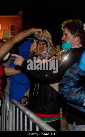 1. Mai 2024, Los Angeles, Kalifornien, USA: Einem pro-palästinensischen Demonstranten werden die Augen gerötet, nachdem sie Pfeffer besprüht haben. Pro-israelische Gegenprotestierende stießen mit pro-palästinensischen Demonstranten zusammen, die ein Lager in der Nähe von Royce Hall an der UCLA in Los Angeles, Kalifornien, aufgebaut haben Der Aufstand dauerte stundenlang in der Nacht am 30. April und dauerte bis in die Morgenstunden des 1. Mai, bis ein paar hundert Polizeibeamte eintrafen, darunter die Universitätspolizei, die California Highway Patrol, das LAPD und die Beverly Hills Police. Die Demonstranten schielten Stöcke und andere Gegenstände wie Regenschirme, kämpften, zerrissen Barrieren, Stockfoto