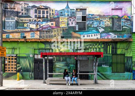 Zwei Frauen plaudern an Einer Bushaltestelle in Valparaiso, Region Valparaiso, Chile. Stockfoto