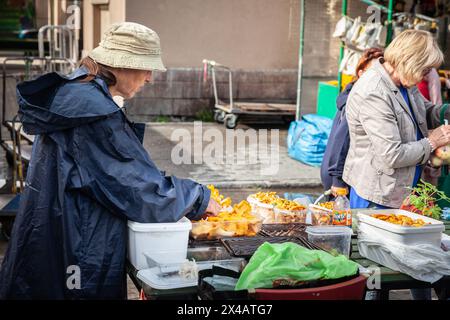 Bild einer älteren Frau, die Wildpilze auf dem rigaer Zentralmarkt in lettland verkauft, hauptsächlich Pfifferlingen. Stockfoto