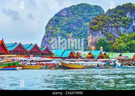 Die bunten Boote, Pfahlhäuser und hohen grünen Felsen im Hintergrund, Ko Panyi Dorf, Phang Nga Bay, Thailand Stockfoto
