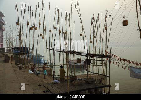 Korbkörbe hängen an langen Bambusstangen am Ufer des Ganges bei Varanasi, Indien. Stockfoto