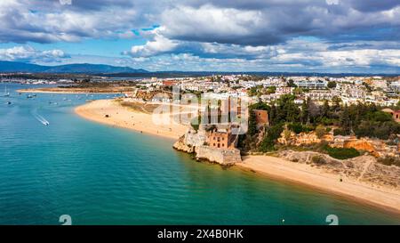 Ferragudo mit dem Praia Grande (Hauptstrand) und dem Fluss Rio Arade, Algarve, Portugal. Wunderschöne Meereslandschaft mit Strand, Höhle und Meer, Praia Gran Stockfoto