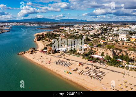 Ferragudo mit dem Praia Grande (Hauptstrand) und dem Fluss Rio Arade, Algarve, Portugal. Wunderschöne Meereslandschaft mit Strand, Höhle und Meer, Praia Gran Stockfoto