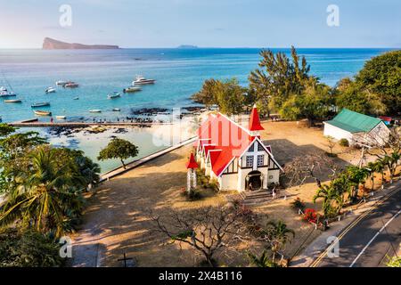 Rote Kirche im Dorf Cap Malheureux auf Mauritius. Notre Dame de Auxiliatrice, ländliche Kirche mit rotem Dach im tropischen Dorf Cap Malheureux auf M Stockfoto