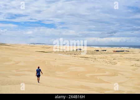 Mann, der durch weite Sanddünen läuft Stockfoto