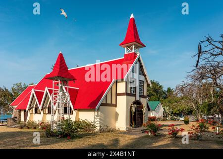 Rote Kirche im Dorf Cap Malheureux auf Mauritius. Notre Dame de Auxiliatrice, ländliche Kirche mit rotem Dach im tropischen Dorf Cap Malheureux auf M Stockfoto