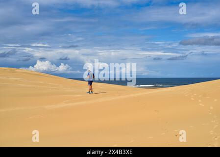 Mann, der durch weite Sanddünen läuft Stockfoto