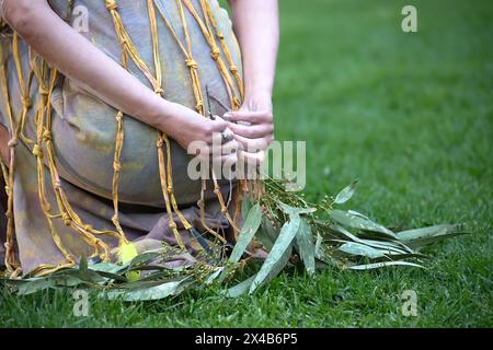 Australische indigene Zeremonie, Frauenhand mit grünen Zweigen, beginnen einen Tanz für einen rituellen Ritus bei einer Gemeindeveranstaltung in Adelaide, South Australia Stockfoto