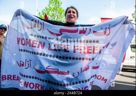 Amsterdam, Niederlande. Mai 2024. Eine Frau hält ein Banner, um iranische Frauen während der Kundgebung zu unterstützen. Am Tag des Internationalen Arbeitstages, auch bekannt als Tag der Arbeit, marschierten die Menschen in Amsterdam, um für alle ein Lebenseinkommen zu fordern, damit sie die schwere Arbeit pünktlich einstellen konnten. Die Demonstration begann am Museumplein im Zentrum der Stadt und wurde von der FNV (dem Verband der niederländischen Gewerkschaften) organisiert. Quelle: SOPA Images Limited/Alamy Live News Stockfoto