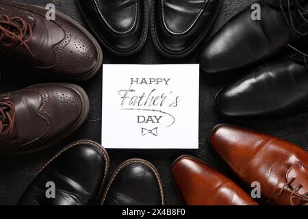 Verschiedene Männerschuhe und Grußkarte mit Text HAPPY FATHER's DAY auf schwarzem Hintergrund Stockfoto