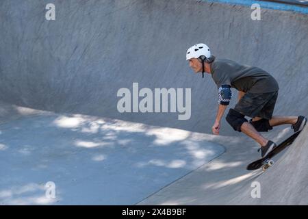 Der 54-jährige brasilianische Skateboarder hat an einem sonnigen Tag Spaß in einem Skatepark 12. Stockfoto