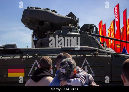 Besucher einer neu eröffneten Ausstellung mit militärischer Trophäenausrüstung, die von russischen Soldaten während des russisch-ukrainischen Krieges gefangen genommen wurde, beobachten ein zerstörtes, in Deutschland hergestelltes Infanterie-Kampffahrzeug 1A3 Marder. Am 1. Mai 2024 eröffnete im Moskauer Siegespark eine Ausstellung mit militärischer Ausrüstung, die von russischen Soldaten während des russisch-ukrainischen Krieges gefangen genommen wurde. Beschädigte, zerstörte und gefangengenommene militärische Ausrüstung der NATO-Länder und der Ukraine wird der russischen Öffentlichkeit ausgestellt. Der russisch-ukrainische Krieg begann am 24. Februar 2024. Seitdem die NATO Stockfoto