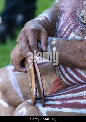 Die menschliche Hand hält rituelle Klappern für den Willkommensritus bei einer indigenen Gemeinde in Australien Stockfoto