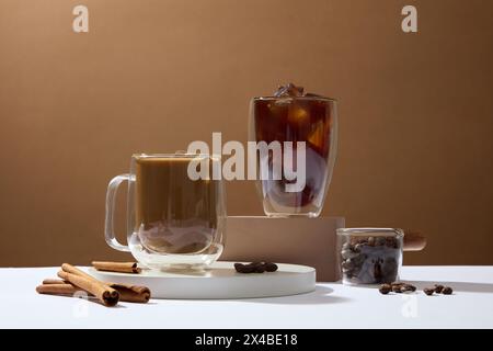 Eine Tasse schwarzen Kaffee und eine Tasse köstlichen Milchkaffee auf dem Podium auf braunem Hintergrund mit Zimtstangen. Zusätzlich zur köstlichen d Stockfoto