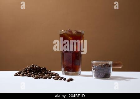 Vorderansicht der Tasse Kaffee und Kaffeebohnen auf braunem Hintergrund. Werbeszene für Getränkeprodukte. Aktives Koffein in Kaffee macht Sie wach, refr Stockfoto