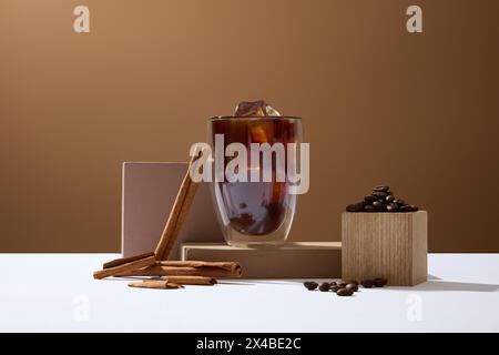 Eine köstliche Tasse Kaffee, dekoriert auf braunem Hintergrund mit gerösteten Kaffeebohnen und Zimtstangen. Werbeszene. Jeden Morgen Kaffee trinken Stockfoto