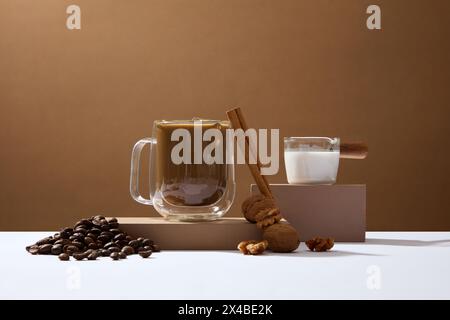 Eine köstliche Tasse Kaffee auf Podesten mit Kaffeebohnen, Zimtstab und Walnuss. Sauberer Kaffee ist ein wirksamer Wirkstoff, der hilft Stockfoto