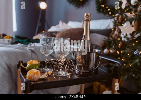 Ein Tablett mit einer Flasche Champagner, zwei Weingläsern und Obst. Die Szene ist feierlich und festlich. Stockfoto