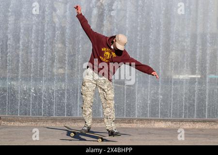 St. Petersburg, Russland. Mai 2024. An einem heißen Tag in St. Petersburg fährt ein Mann auf dem Moskowskaja-Platz vor der Kulisse des Brunnenkomplexes Skateboarden. Quelle: SOPA Images Limited/Alamy Live News Stockfoto