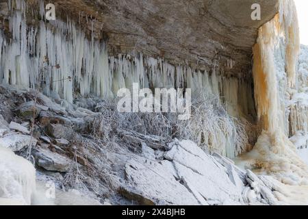 Winter-Wasserfall in Eiszapfen gefroren. Atemberaubende gefrorene Eiszapfen hängen von felsigen Bergklippen. Jagala, Estland. Stockfoto