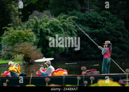 Eine junge Familie genießt eine geführte Gondelfahrt im Teich. Stockfoto