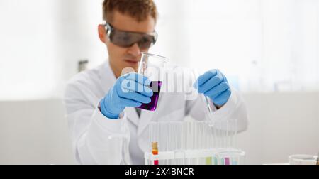 Eine männliche Chemiker hält Reagenzglas von Glas in Stockfoto
