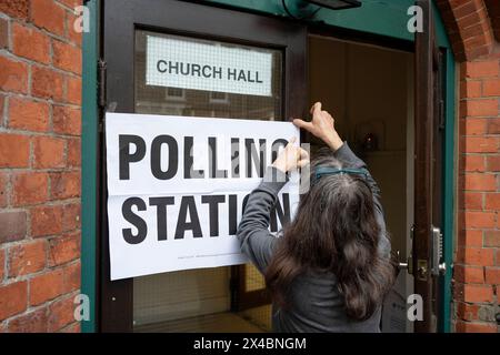 Ein Mitarbeiter bringt Plakate vor der Wahlstation der Baptist Church in East Dulwich an dem Tag, an dem die Londoner am 2. Mai 2024 in London für ihren Bürgermeister und die Mitglieder der Londoner Versammlung stimmen. Stockfoto