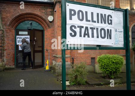 Ein Mitarbeiter bringt Plakate vor der Wahlstation der Baptist Church in East Dulwich an dem Tag, an dem die Londoner am 2. Mai 2024 in London für ihren Bürgermeister und die Mitglieder der Londoner Versammlung stimmen. Stockfoto