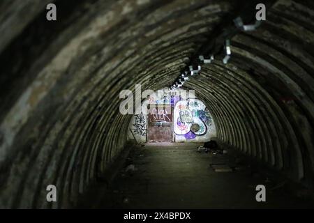 Verlassener Tunnelbunker, teilweise durch eine Taschenlampe beleuchtet. Stockfoto